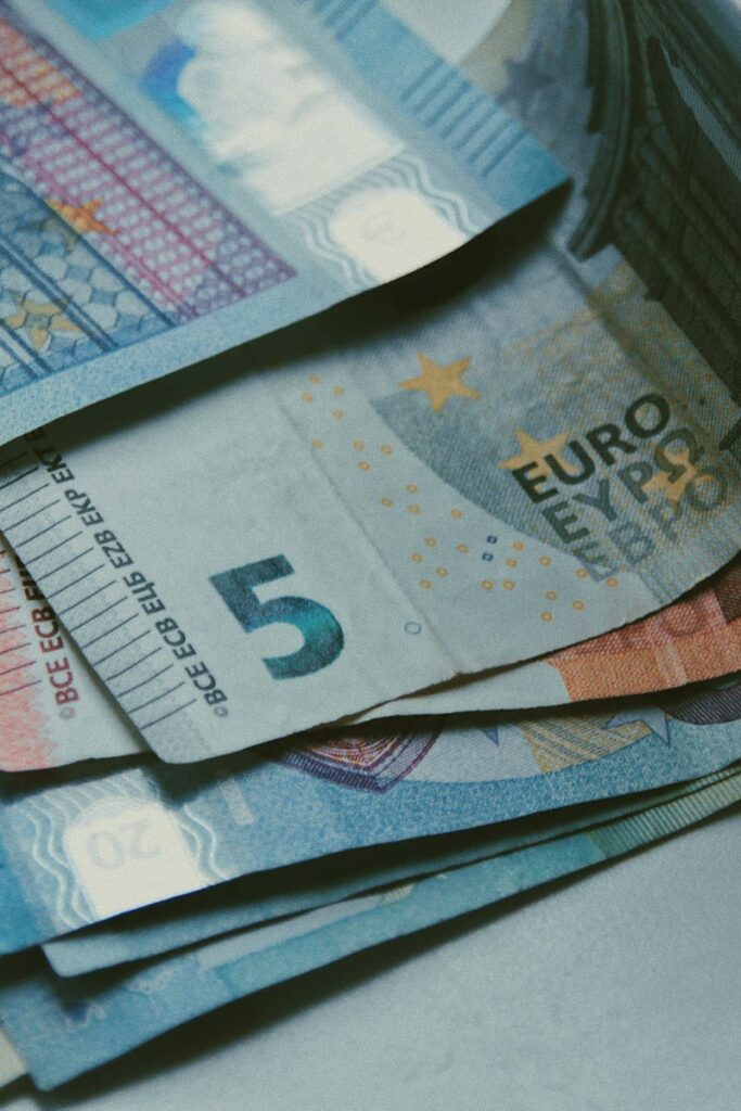 Detailed close-up of various Euro banknotes on a white surface, perfect for finance-related content.